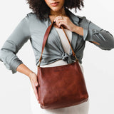 Nutmeg Classic | Model carrying leather triangular shoulder bag with zipper top closure and wide shoulder strap