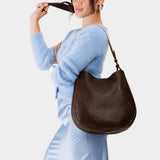 Coldbrew Large | Woman wearing rounded shoulder bag with adjustable strap on a white background