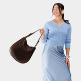 Coldbrew Large | Woman wearing rounded shoulder bag with adjustable strap on a white background