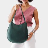 Forest Green Large | Woman wearing rounded shoulder bag with adjustable strap on a white background