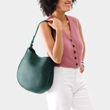 Forest Green Large | Woman wearing rounded shoulder bag with adjustable strap on a white background