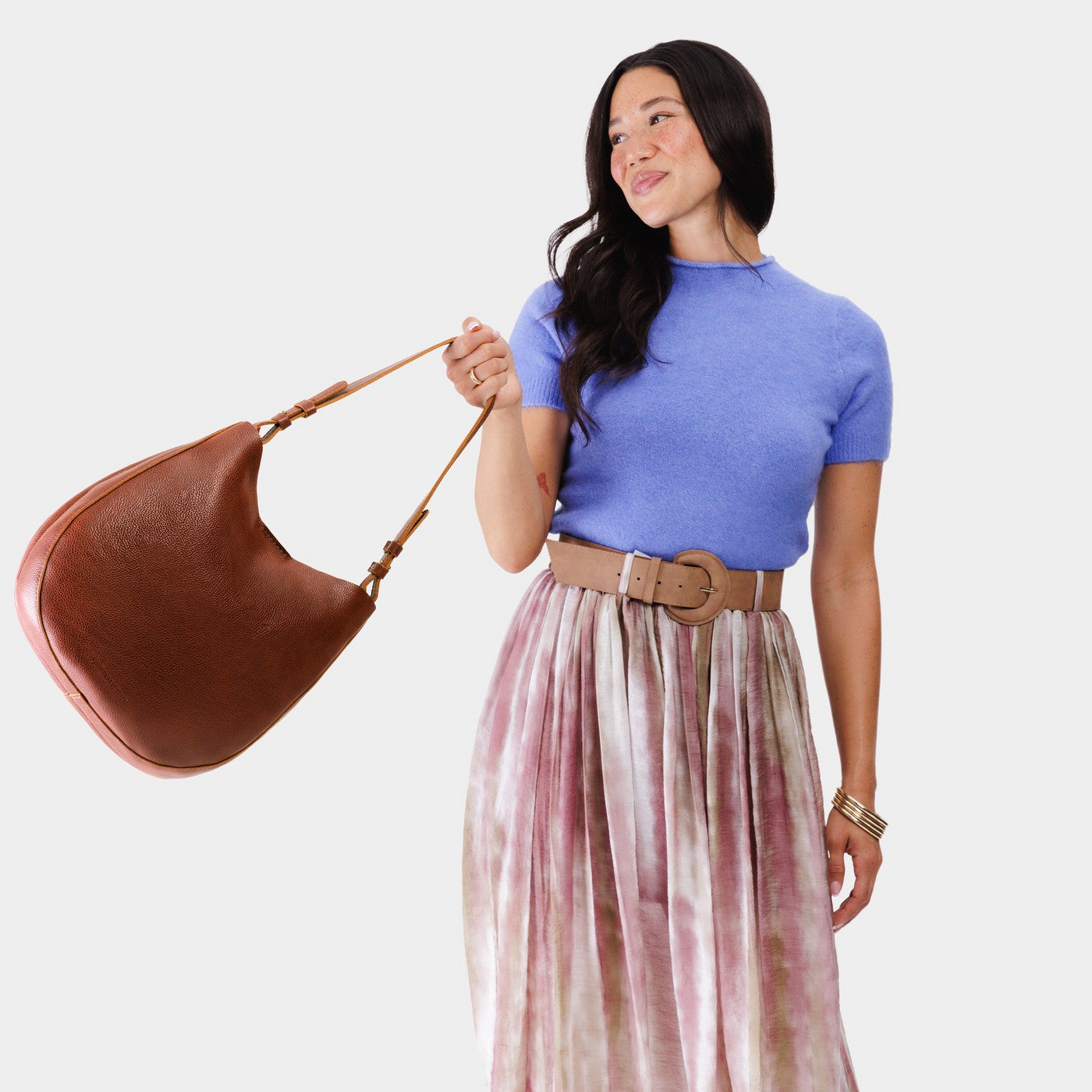 Nutmeg*Large | Woman wearing rounded shoulder bag with adjustable strap on a white background