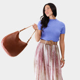 Nutmeg Large | Woman wearing rounded shoulder bag with adjustable strap on a white background