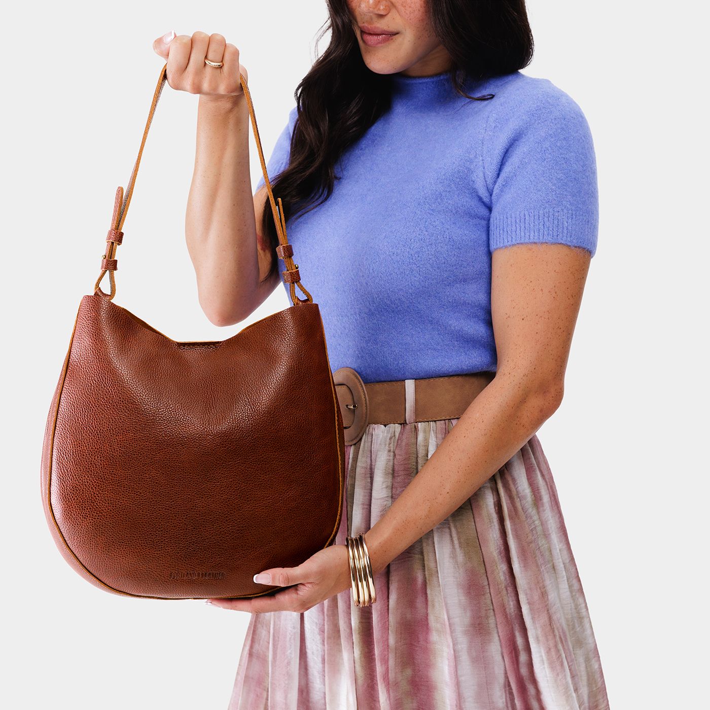 Nutmeg*Large | Woman wearing rounded shoulder bag with adjustable strap on a white background