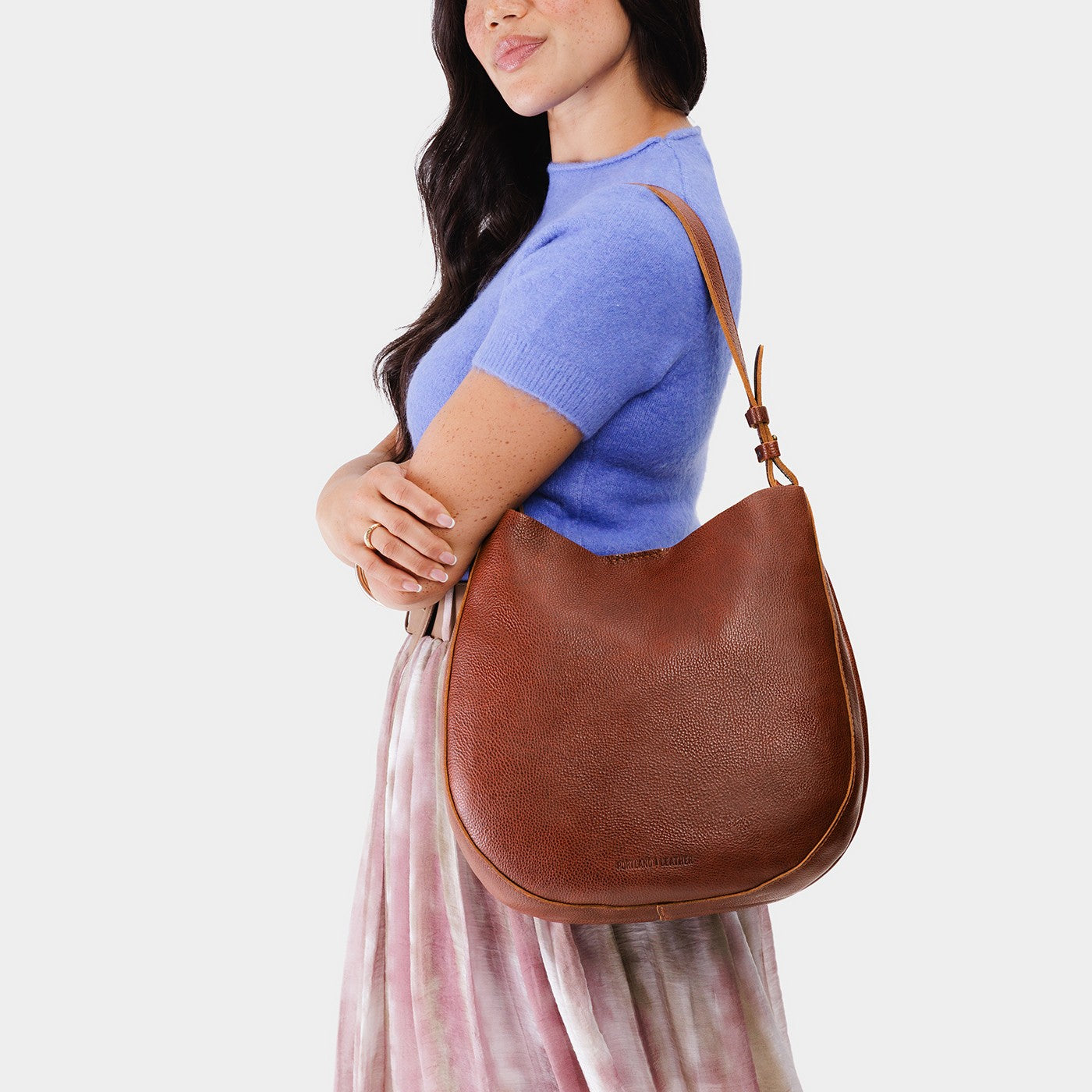 Nutmeg*Large | Woman wearing rounded shoulder bag with adjustable strap on a white background