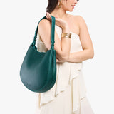 Sea Glass Large | Model holding round leather purse with adjustable shoulder strap