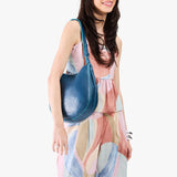 Caspian Medium | Model holding round leather purse with adjustable shoulder strap