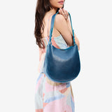 Caspian Medium | Model holding round leather purse with adjustable shoulder strap