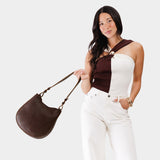 Coldbrew Medium | Woman wearing rounded shoulder bag with adjustable strap on a white background