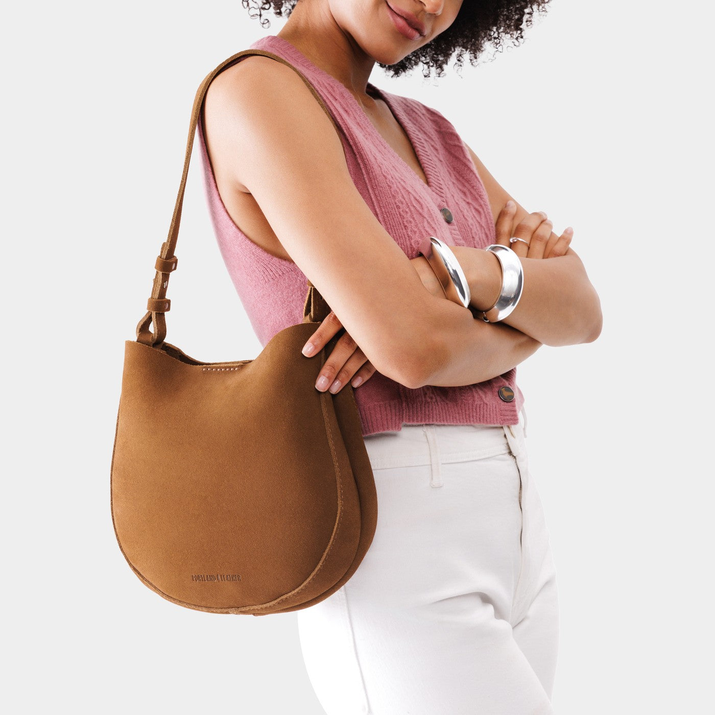 Jackson*Medium | Woman wearing rounded shoulder bag with adjustable strap on a white background