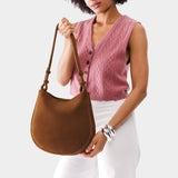 Jackson Medium | Woman wearing rounded shoulder bag with adjustable strap on a white background