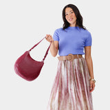 Orchid Medium | Woman wearing rounded shoulder bag with adjustable strap on a white background