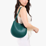 Sea Glass Medium | Model carrying round leather purse with adjustable shoulder strap