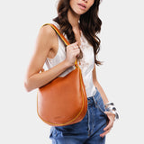 Sienna Medium | Woman wearing rounded shoulder bag with adjustable strap on a white background