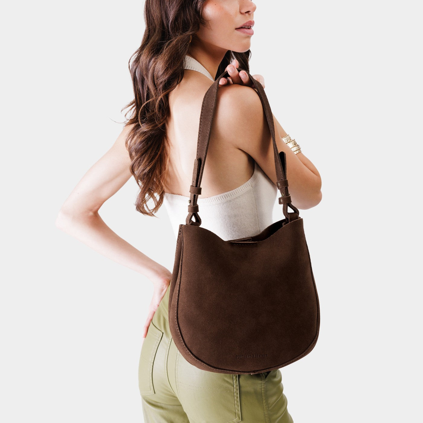Stagecoach*Medium | Woman wearing rounded shoulder bag with adjustable strap on a white background