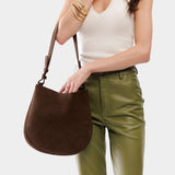 Stagecoach Medium | Woman wearing rounded shoulder bag with adjustable strap on a white background