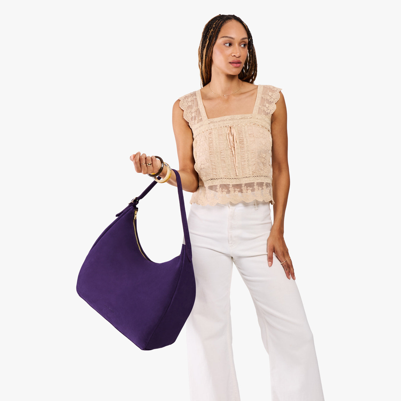 Imperial*Oversized | Model holding u-shaped, flat-bottomed leather shoulder bag with adjustable strap