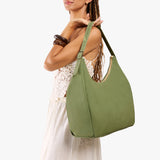 Laurel Oversized | Model holding u-shaped, flat-bottomed leather shoulder bag with adjustable strap