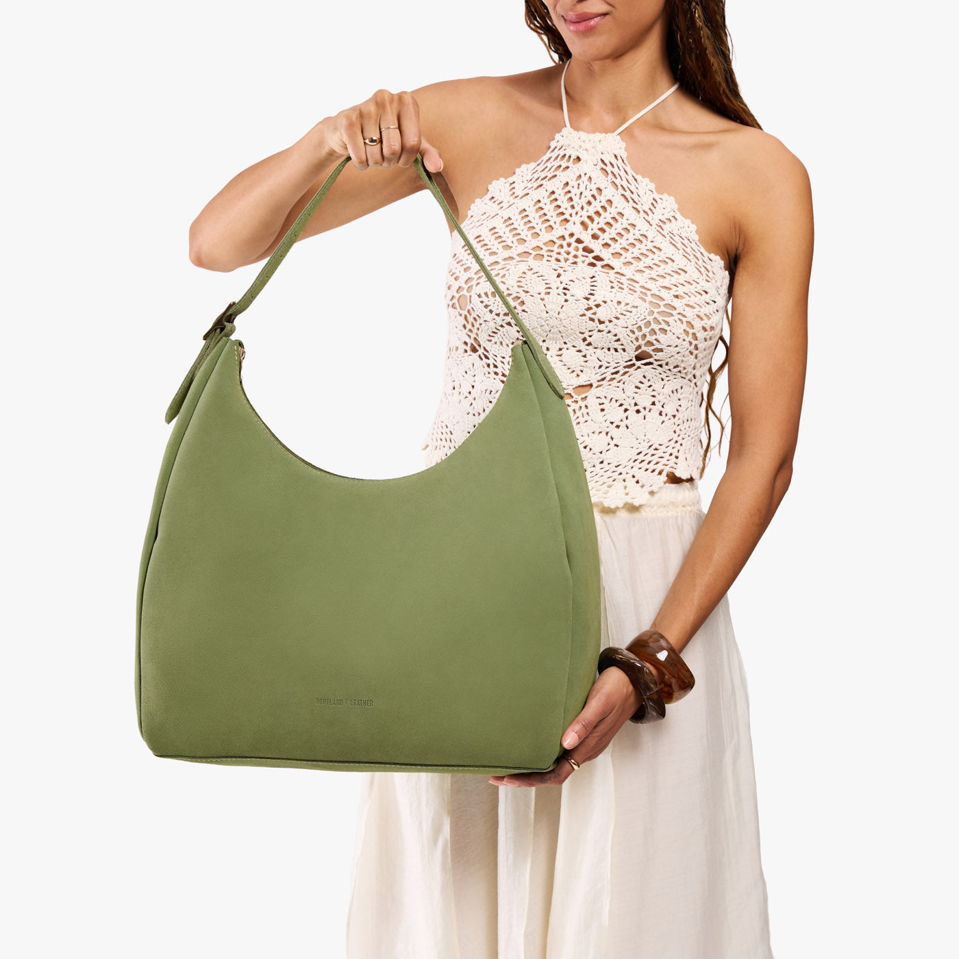 Laurel*Oversized | Model holding u-shaped, flat-bottomed leather shoulder bag with adjustable strap