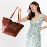 Nutmeg Oversized | Model holding extra wide bucket shaped tote bag with matching leather handles