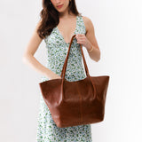 Nutmeg Oversized | Model holding extra wide bucket shaped tote bag with matching leather handles