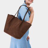 Stagecoach Oversized | Model holding extra wide bucket shaped tote bag with matching leather handles