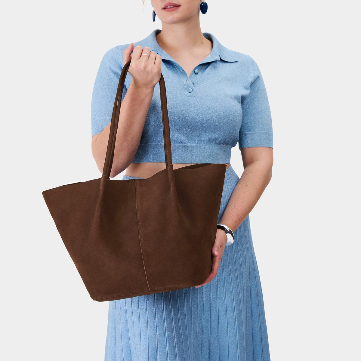Stagecoach*Oversized | Model holding extra wide bucket shaped tote bag with matching leather handles