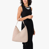 Toasted Oat Oversized | Model holding large shoulder bag with adjustable strap and magnetic snap closure