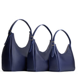 Cobalt | Size comparison image of oversized, large, and medium u-shaped, flat-bottomed leather shoulder bags with adjustable strap
