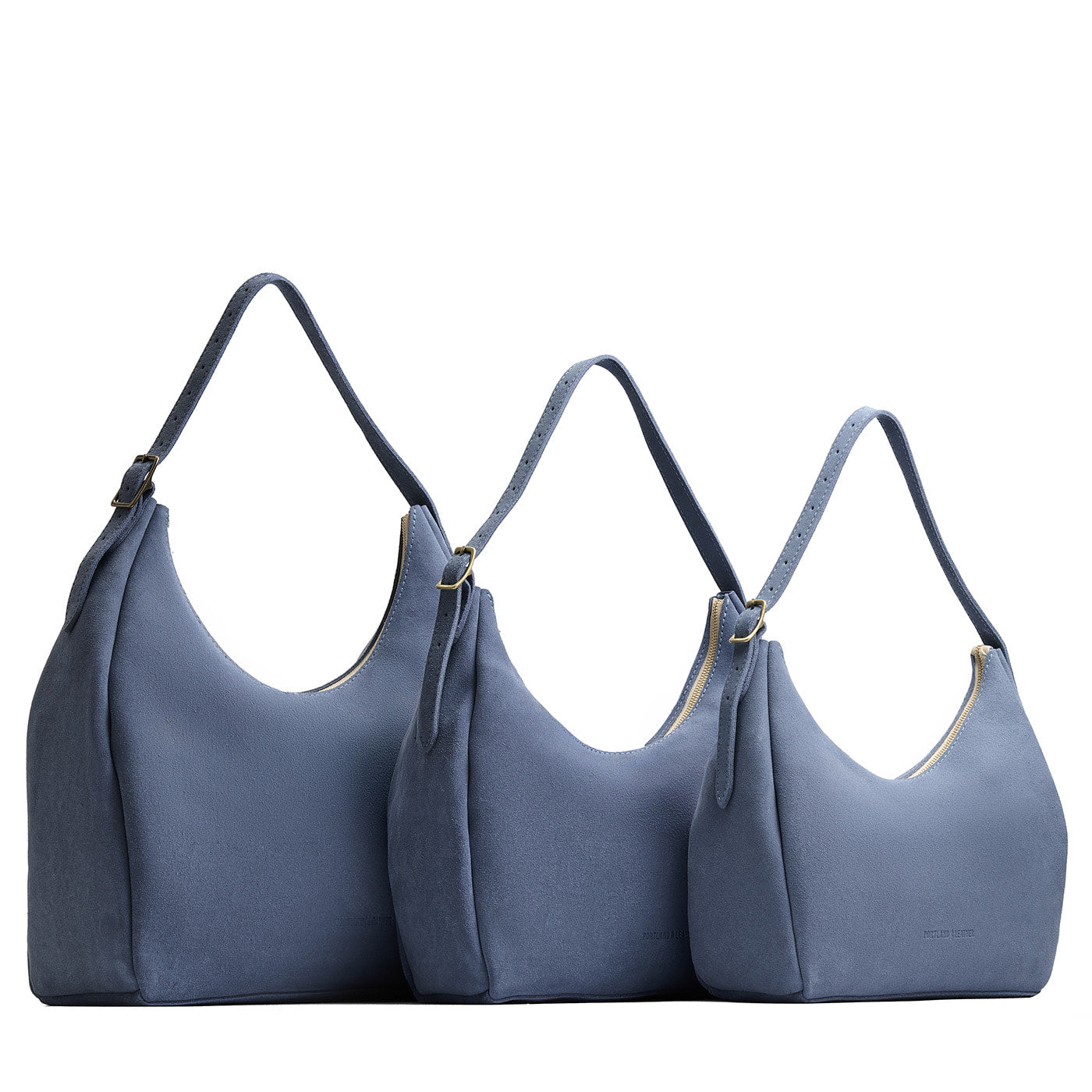 Denim | Size comparison image of oversized, large, and medium u-shaped, flat-bottomed leather shoulder bags with adjustable strap