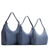 Denim | Size comparison image of oversized, large, and medium u-shaped, flat-bottomed leather shoulder bags with adjustable strap
