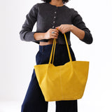 Hello Yellow Oversized | Model holding extra wide bucket shaped tote bag with matching leather handles