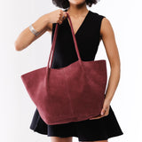 Red Panda Oversized | Model holding extra wide bucket shaped tote bag with matching leather handles