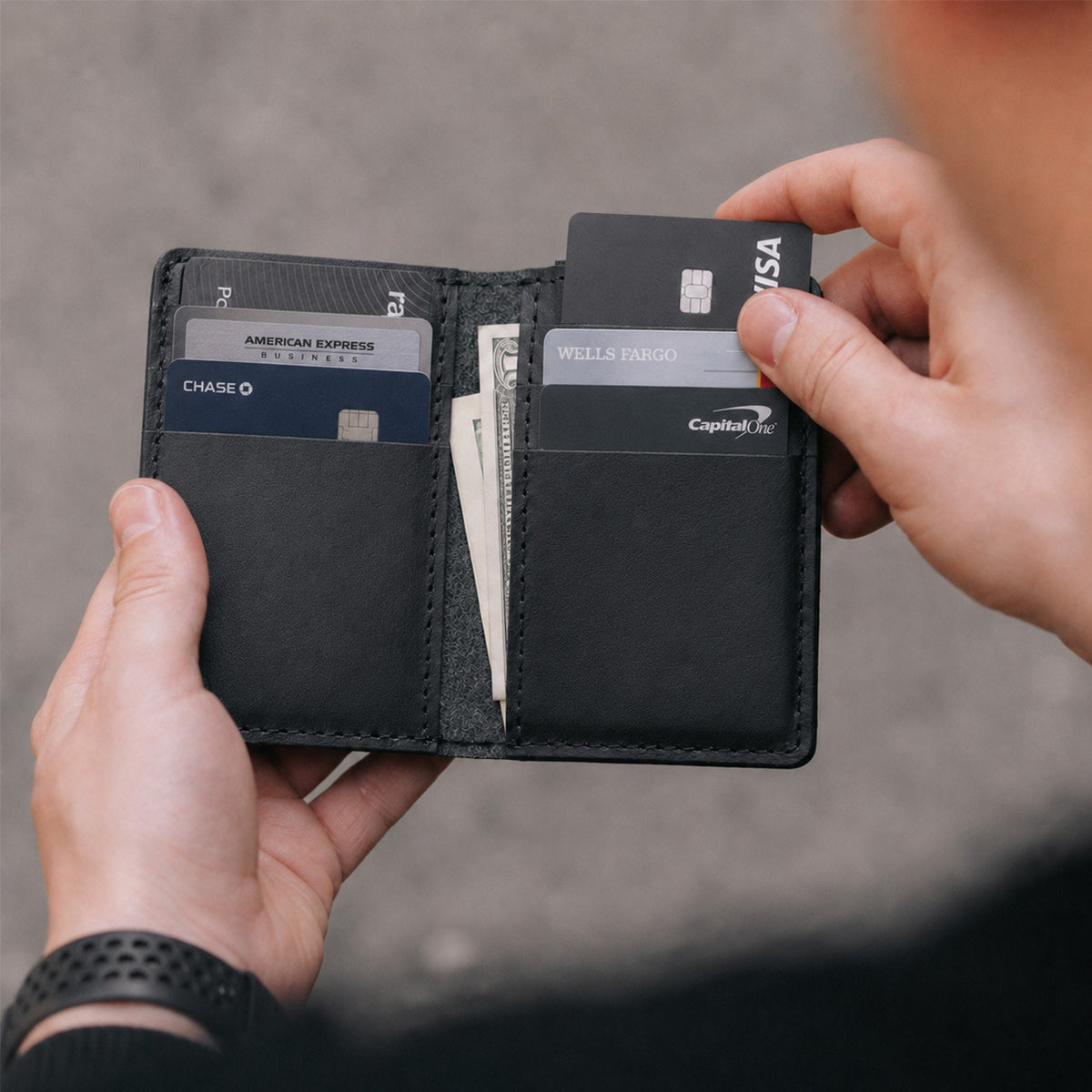 Nero | An open card holder with hands pulling cards out of one of the interior card slots