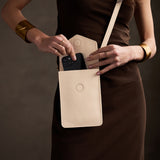 Pebbled Bone | Model wearing slim, phone-shaped crossbody purse with magnetic closure