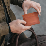 Toscano | A close-up lifestyle shot of a model holding a leather card holder