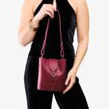 Berry Good | Model wearing leather bucket shoulder bag with adjustable strap and magnetic closure 
