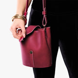 Berry Good | Model wearing leather bucket shoulder bag with adjustable strap and magnetic closure 