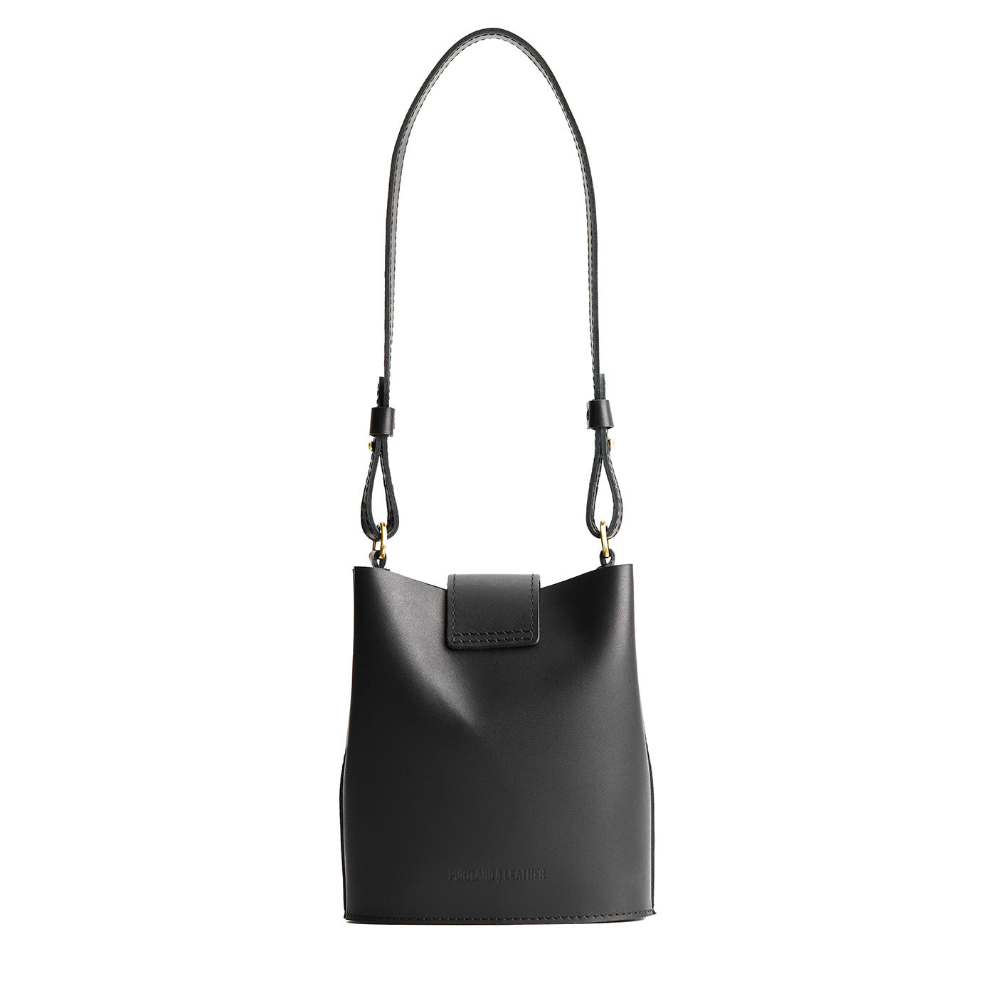 Black | Leather bucket shoulder bag with adjustable strap and magnetic closure on a white background