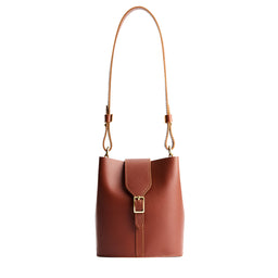Chestnut | Leather bucket shoulder bag with adjustable strap and magnetic closure on a white background