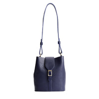 Cobalt | Leather bucket shoulder bag with adjustable strap and magnetic closure on a white background