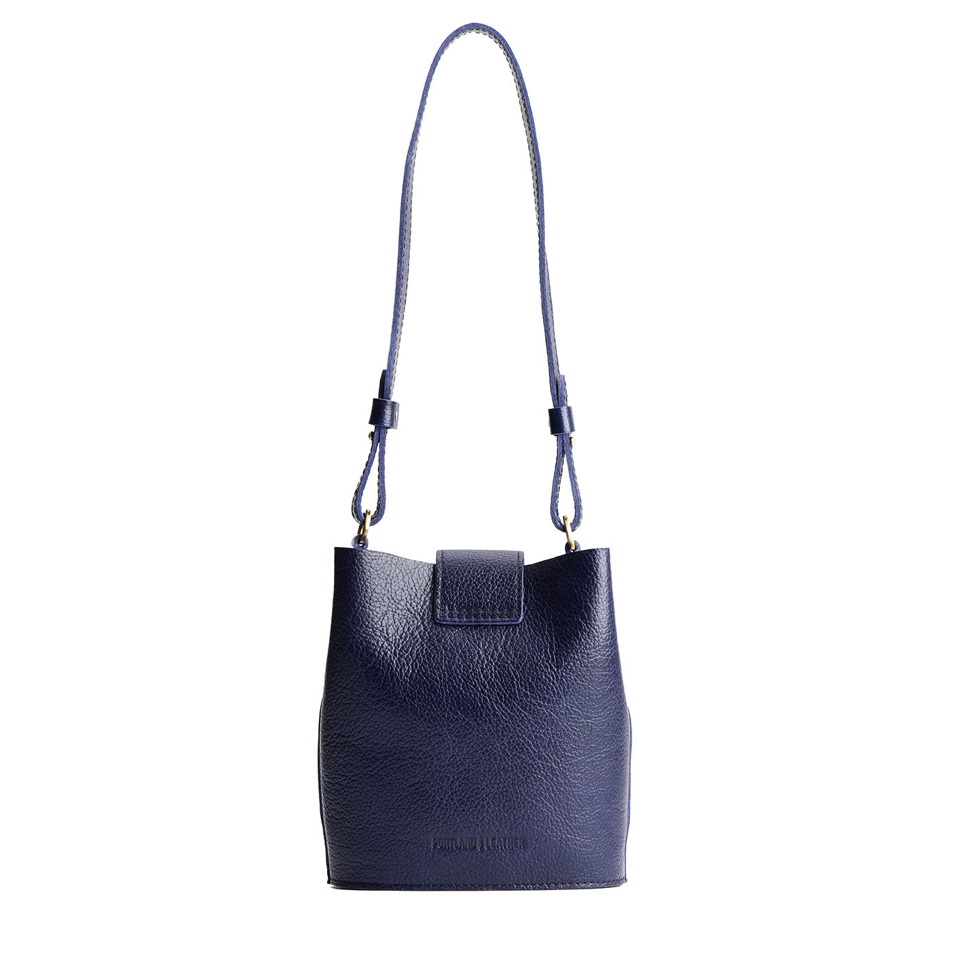 Cobalt | Leather bucket shoulder bag with adjustable strap and magnetic closure on a white background