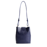 Cobalt | Leather bucket shoulder bag with adjustable strap and magnetic closure on a white background