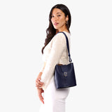 Cobalt | Model wearing leather bucket shoulder bag with adjustable strap and magnetic closure 