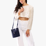 Cobalt | Model wearing leather bucket shoulder bag with adjustable strap and magnetic closure 