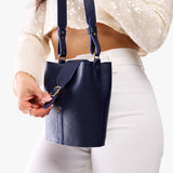 Cobalt | Model wearing leather bucket shoulder bag with adjustable strap and magnetic closure 