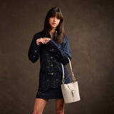 Dragon Bone | Model wearing leather bucket shoulder bag with adjustable strap and magnetic closure 