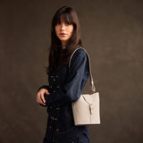 Dragon Bone | Model wearing leather bucket shoulder bag with adjustable strap and magnetic closure 