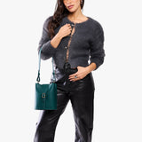 Harbor | Model wearing leather bucket shoulder bag with adjustable strap and magnetic closure 