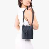 Night Owl | Model wearing leather bucket shoulder bag with adjustable strap and magnetic closure 